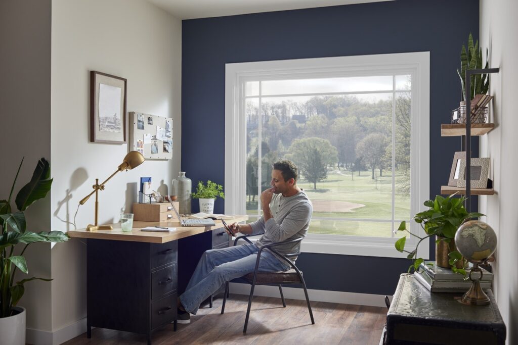 man sitting in home office with picture window